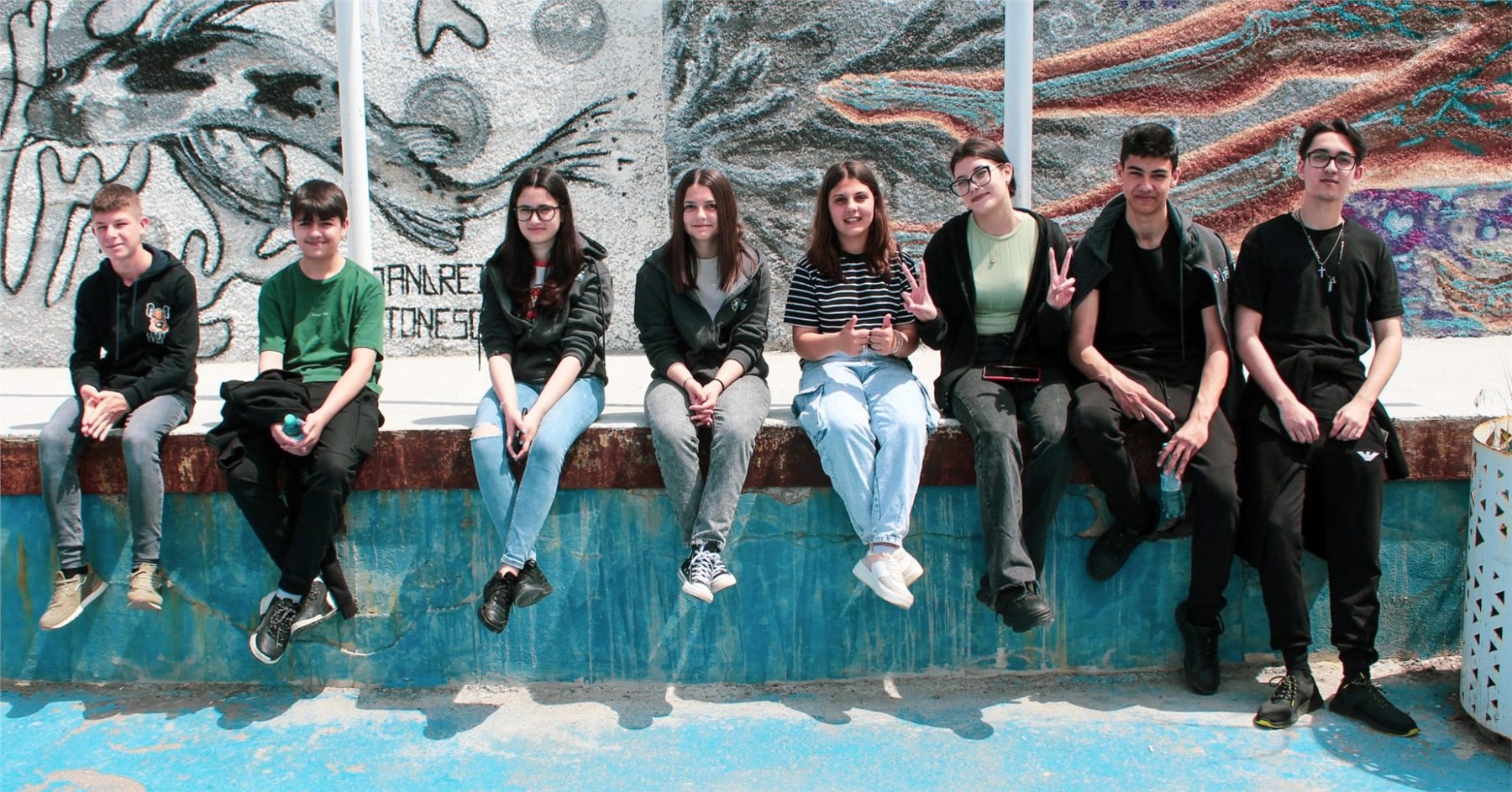 Tineri din Cogealac în fața unui mural comunitar